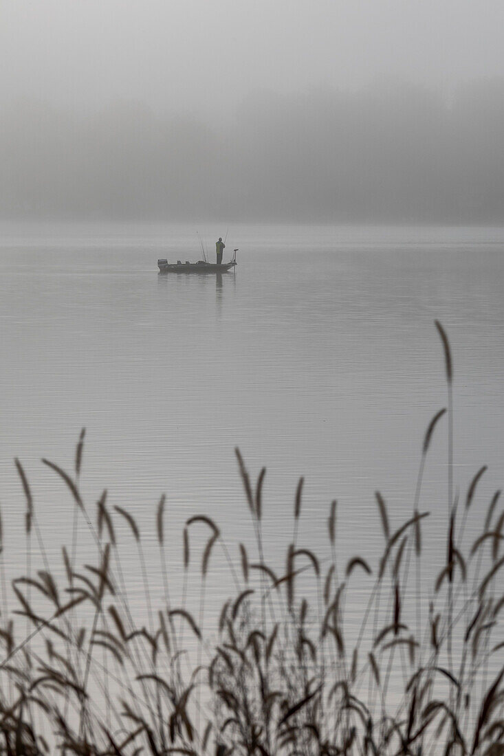 Fisherman on a foggy lake