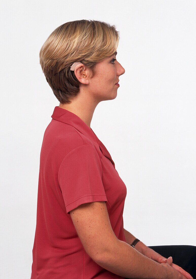 Woman in polo shirt wearing hearing aid