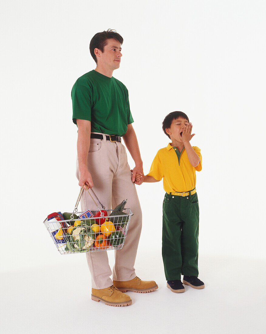 Man holding a shopping basket and holding hands with a boy