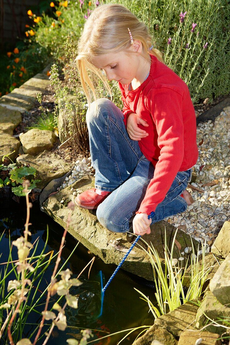 Girl holding fishing net in water