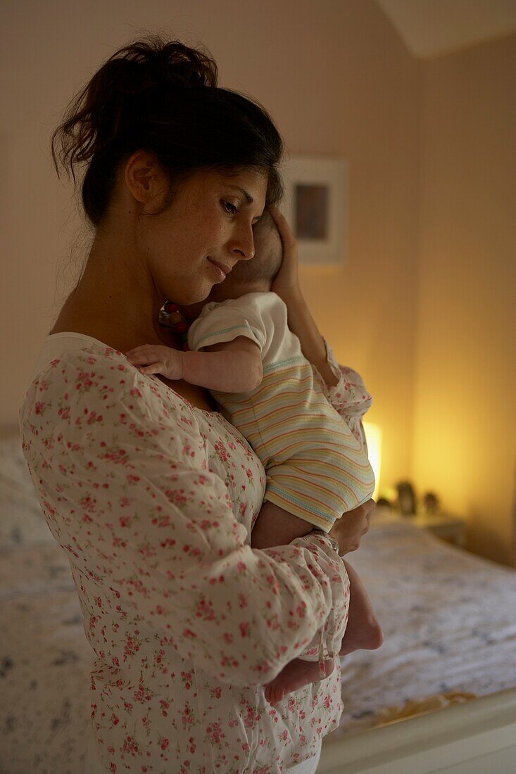 Woman in pyjamas holding a baby boy