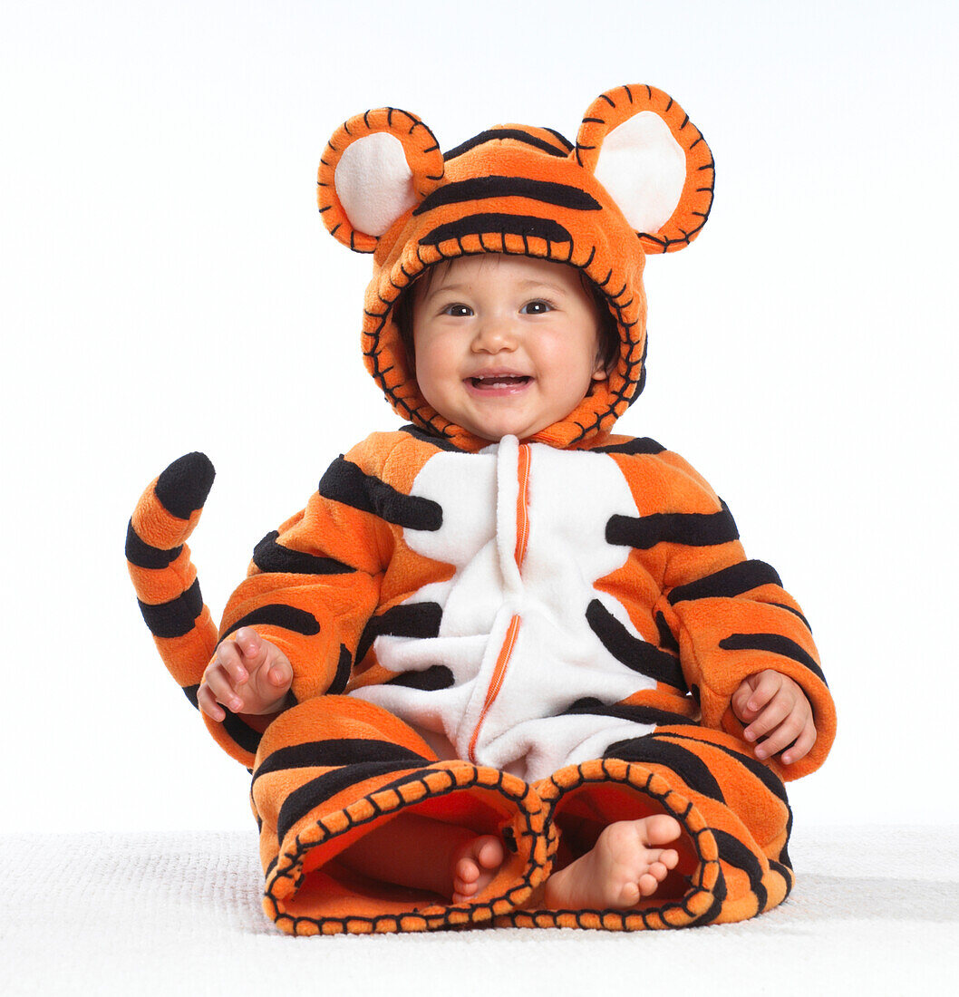 Smiling baby girl wearing tiger costume