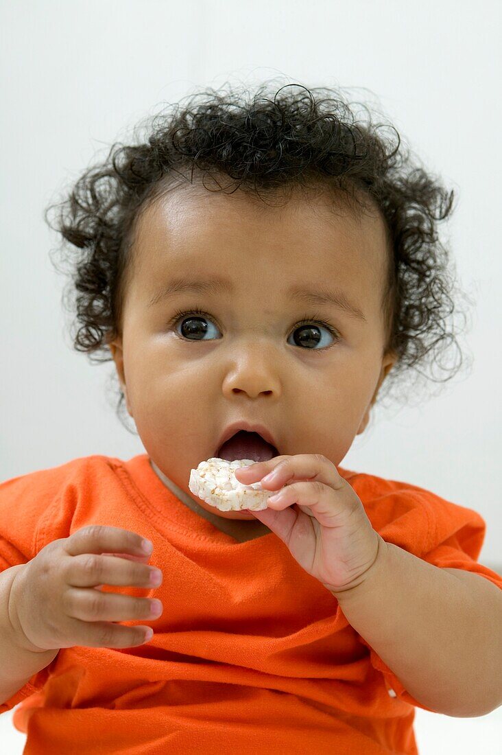 Baby girl eating cookie
