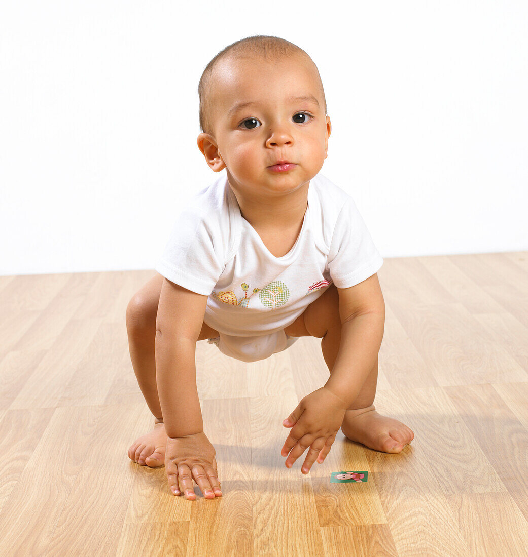 Baby boy squatting on floor