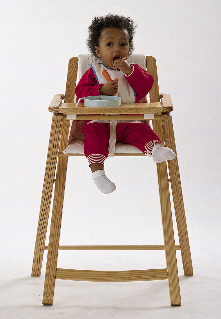 Baby in high-chair eating meal