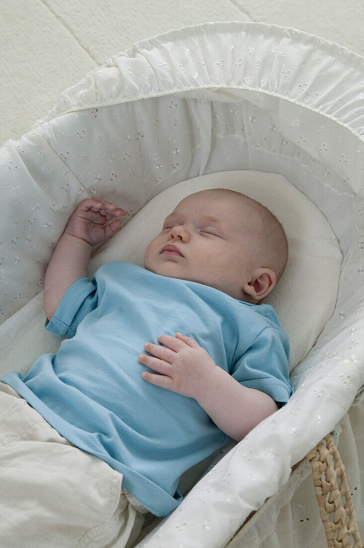Baby boy lying in basket sleeping