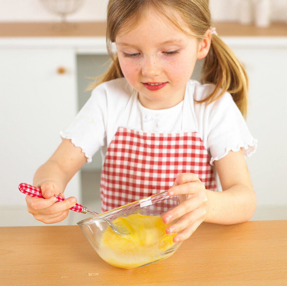 Girl holding fork in bowl with eggs in