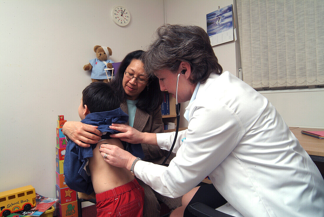 Woman holding stethoscope to boy's back