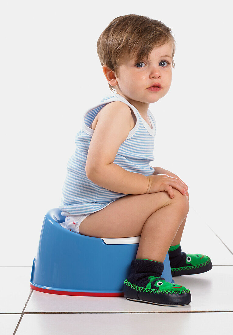 Boy sitting on a blue potty