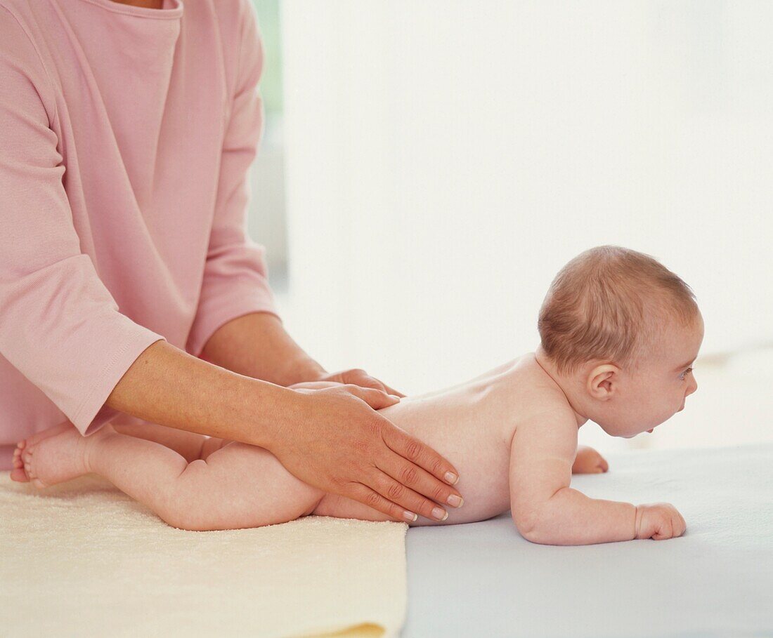 Woman placing both hands on baby's back