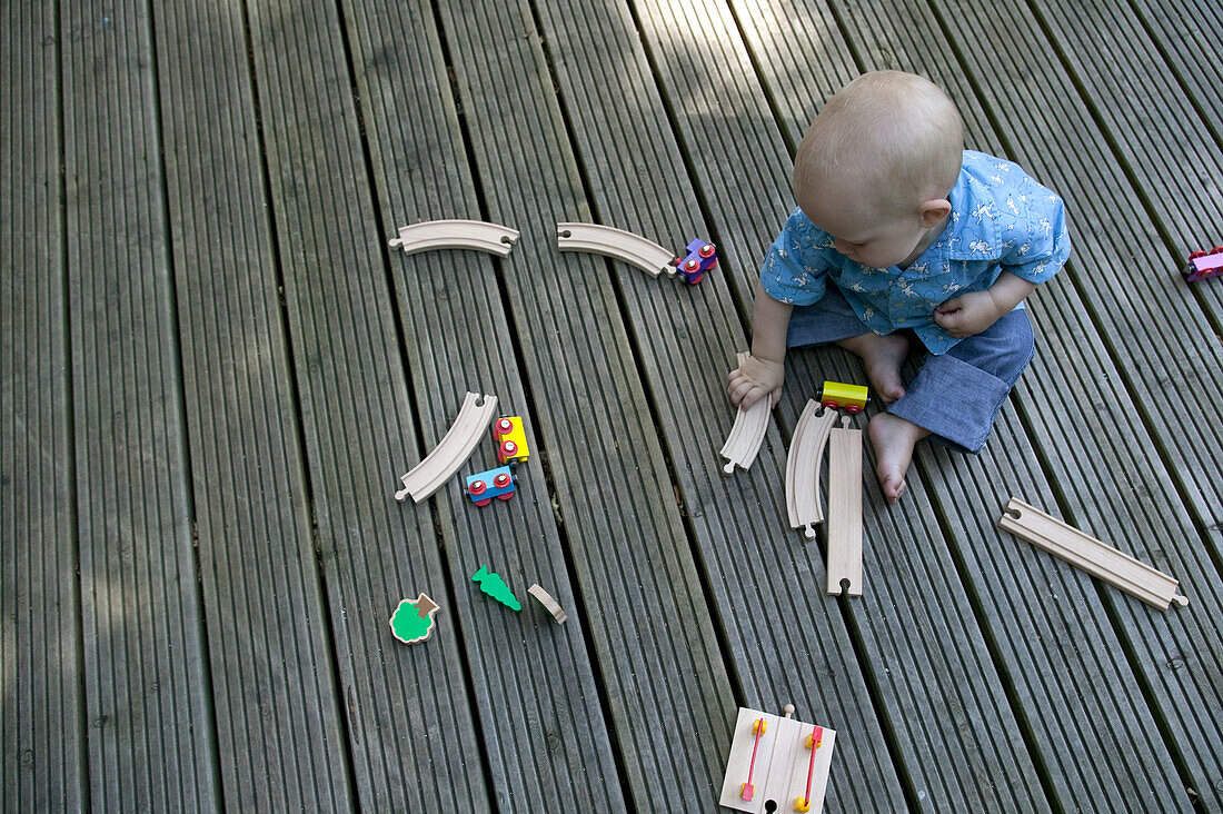 Baby boy playing with toy railway and train