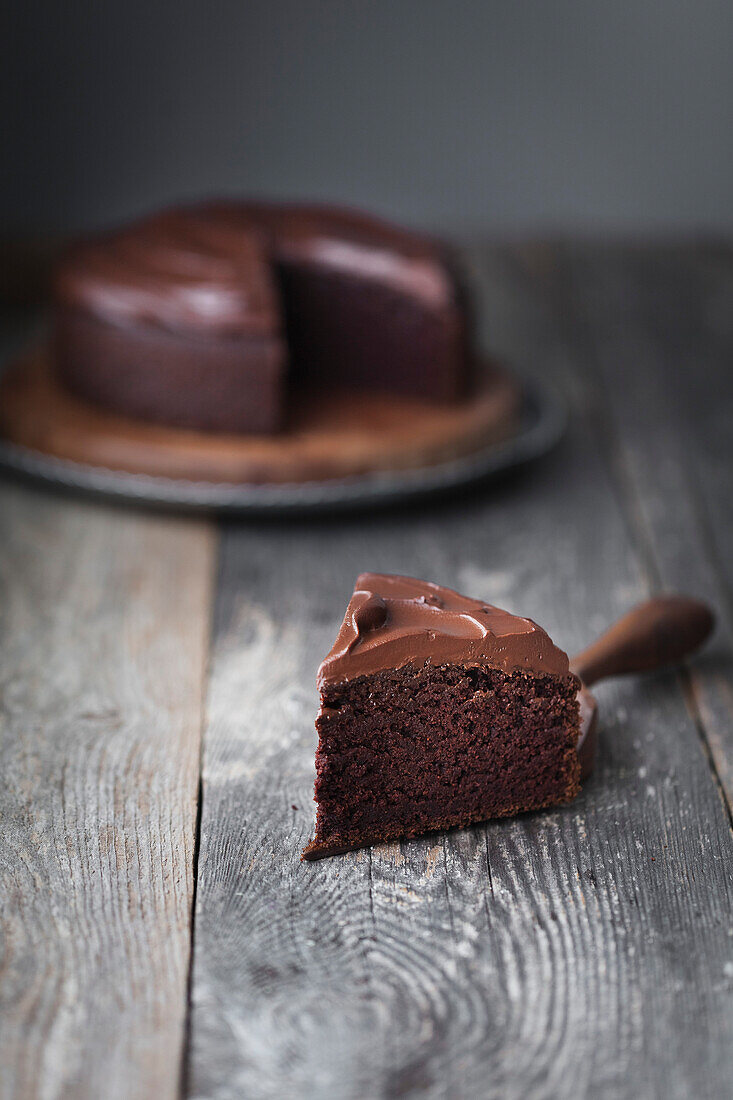 Schokoladenkuchen mit Frosting, ein Stück auf Kuchenheber