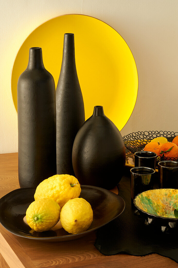 Stillleben mit schwarzen Vasen und Zitrusfrüchten