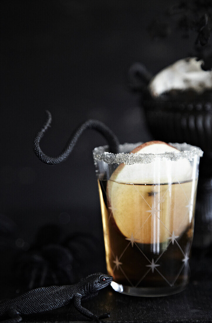 Cider cocktail with cinnamon sugar rim and lizard decoration