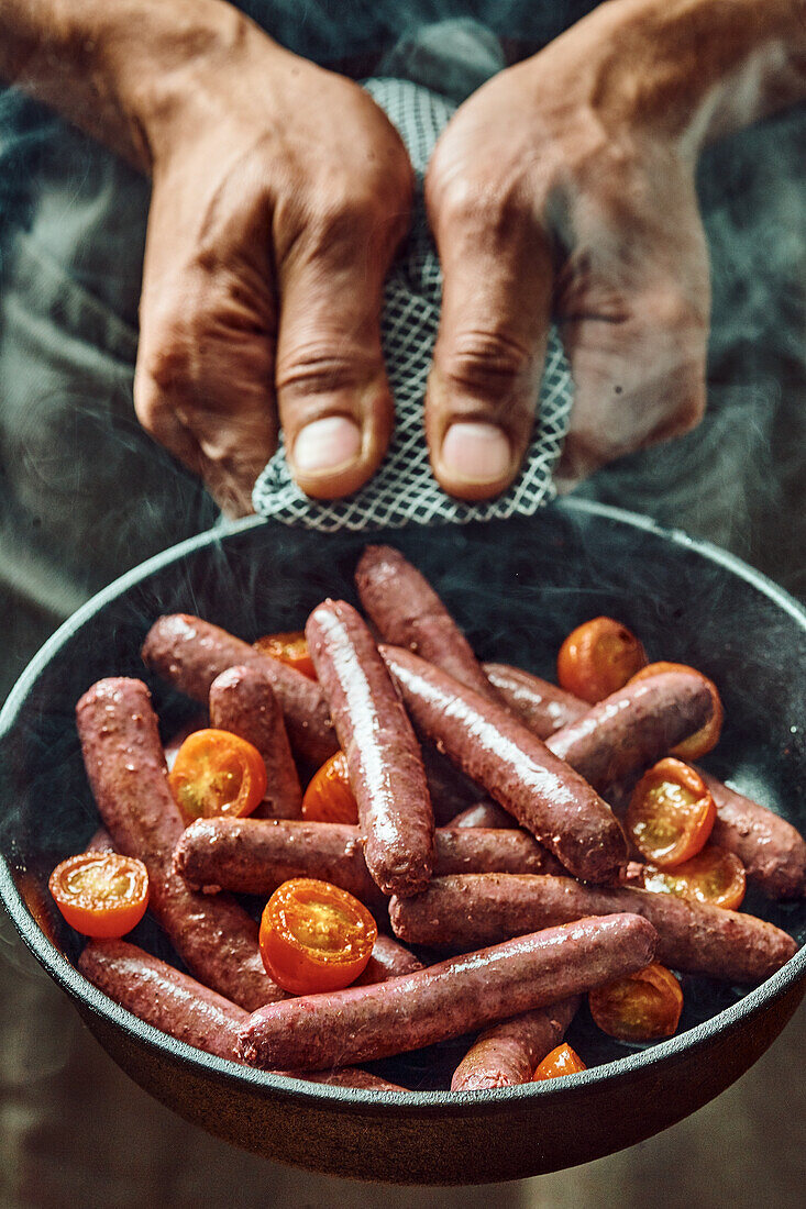 Fried sausages with tomatoes in a pan
