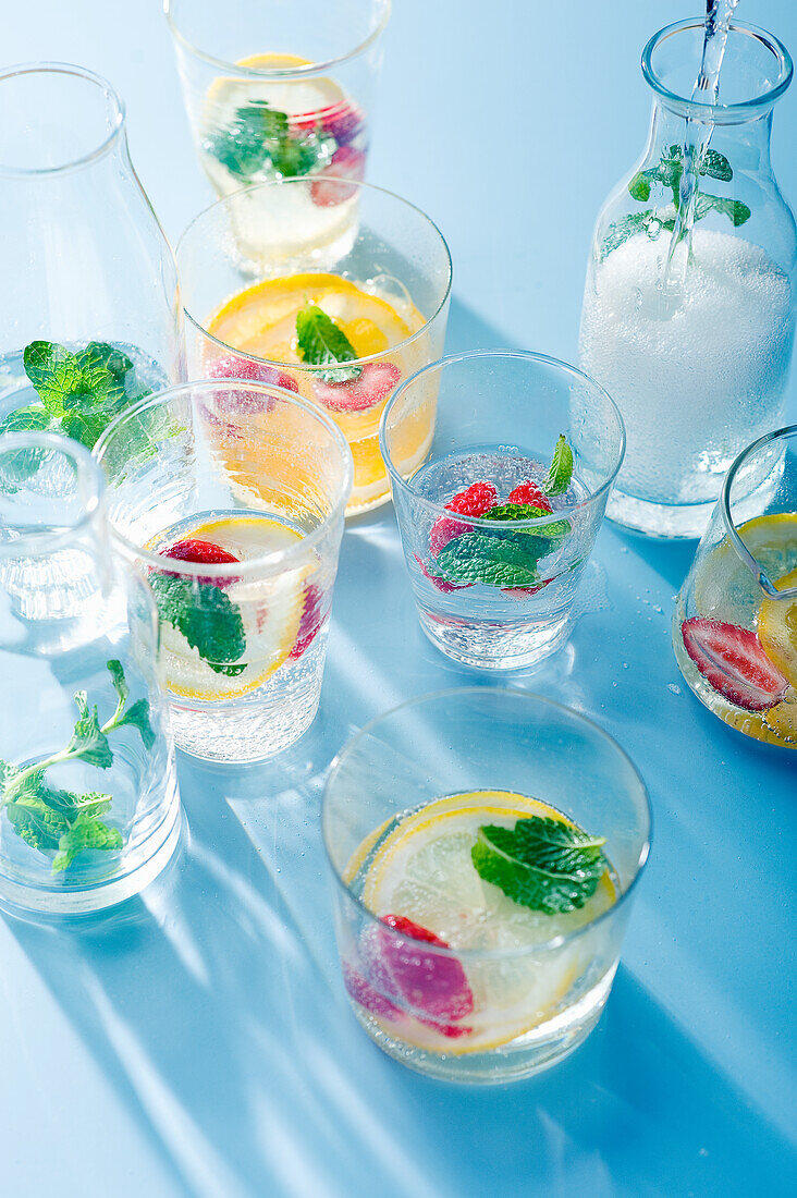Glasses of lemonade with lemon and strawberry slices