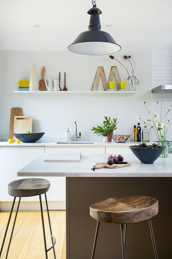 Kitchen island with bar stools in white kitchen-dining room