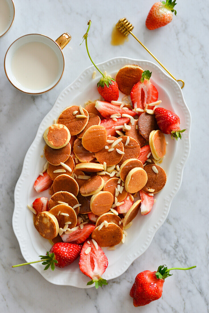 Mini pancakes with strawberries and maple syrup
