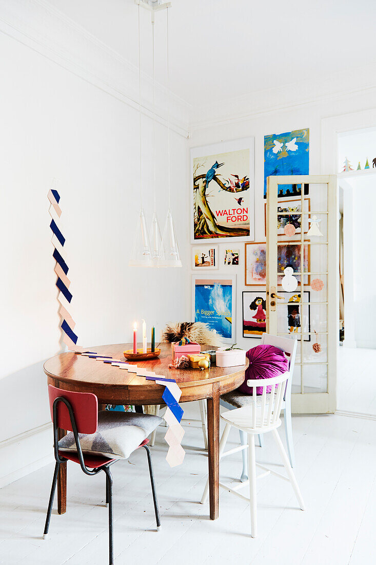 Antique table with chairs and a gallery wall behind a door