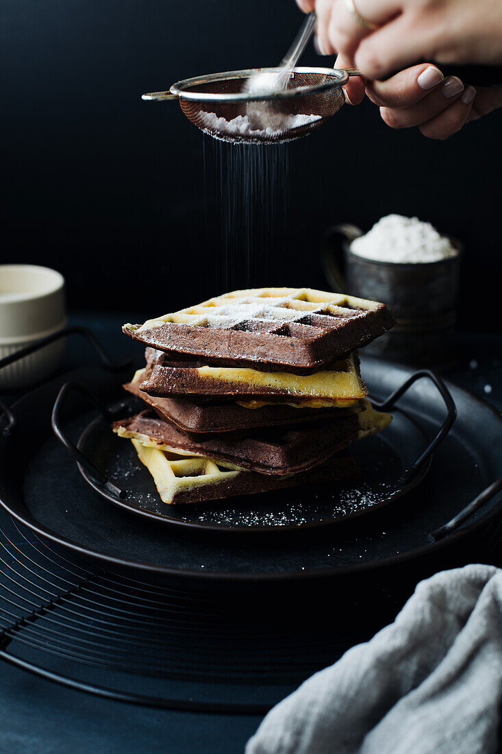 Marbel waffles being dusted with icing sugar