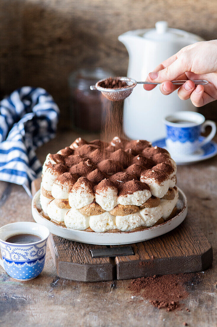 Tiramisu-Kuchen wird mit Kakaopulver bestäubt