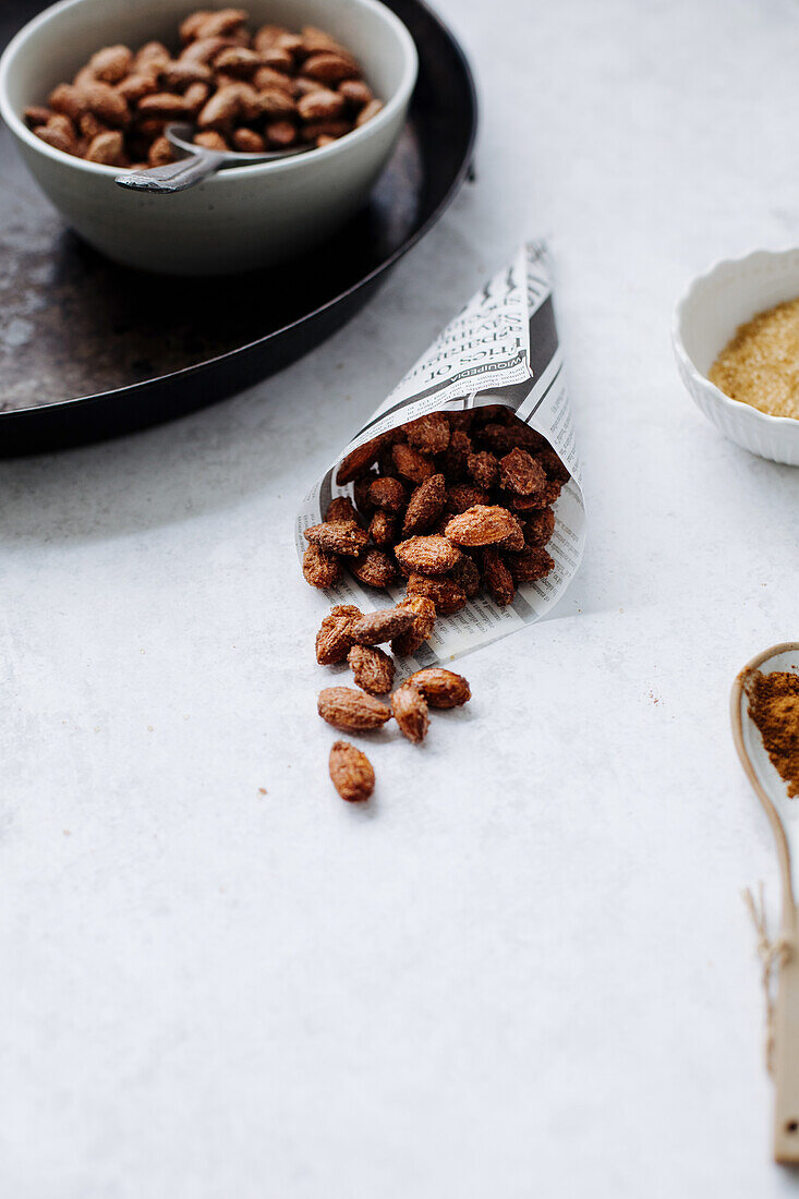 Roasted almonds in small bowls and a paper bag