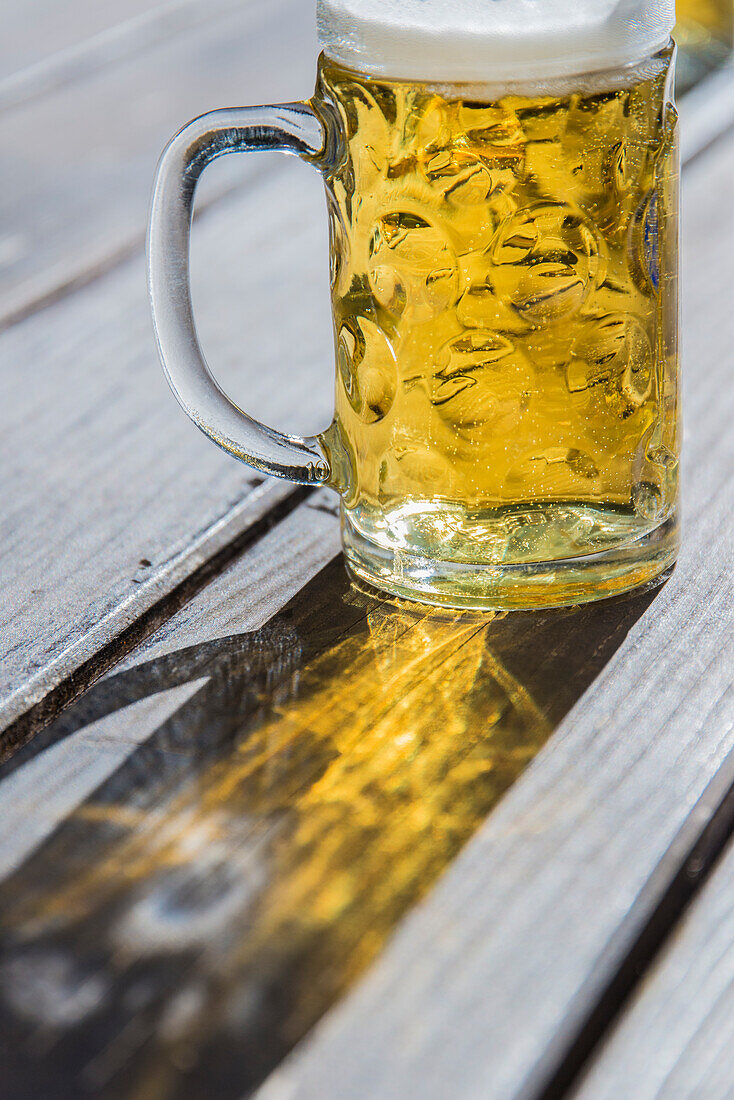 Bier im Maßkrug auf Holztisch