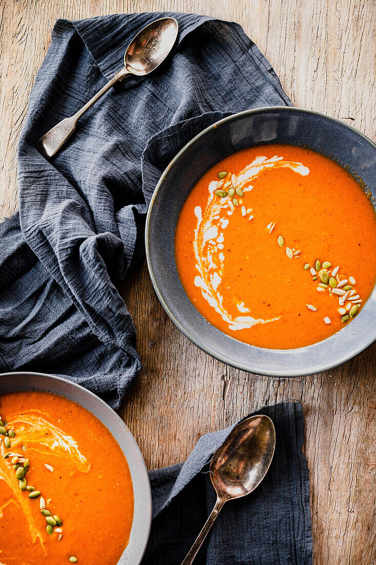 Tomato soup, topped with a swirl of cream and pumpkin seeds