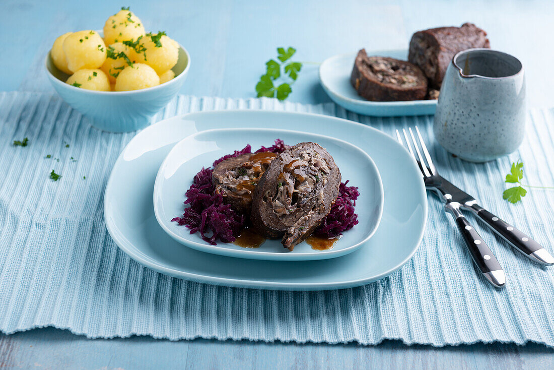 Veganer Seitanrollbraten mit Pilz-Zwiebel-Füllung, dazu Rotkohl und Klöße