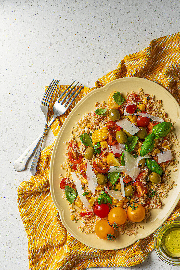 Couscous-Salat mit Tomaten, Mais, Oliven, Basilikum  und Parmesan