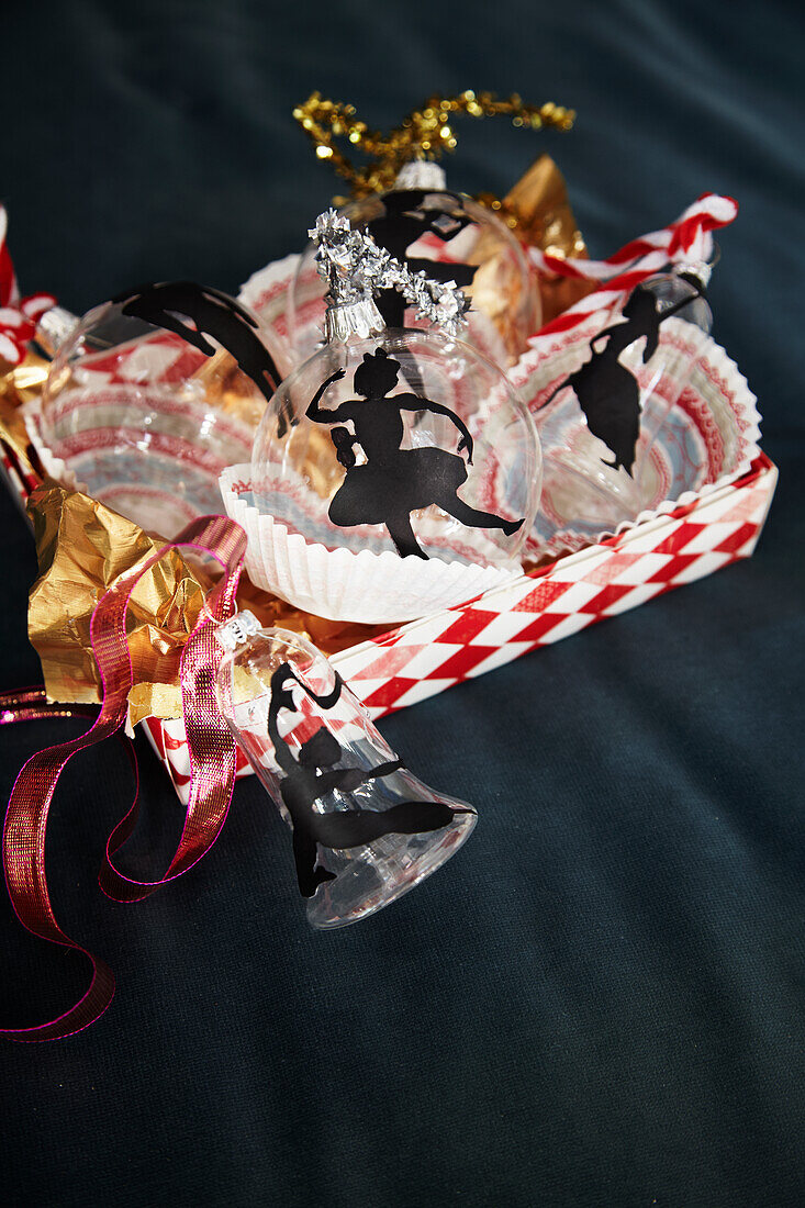 DIY Christmas tree decorations: silhouettes made of black clay paper on glass baubles and bells