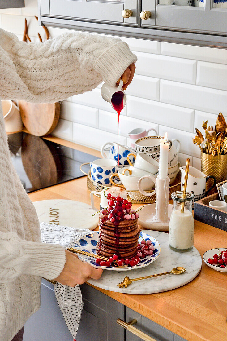 Schokoladen-Pancakes mit roten Johannisbeeren, mit Sauce beträufeln