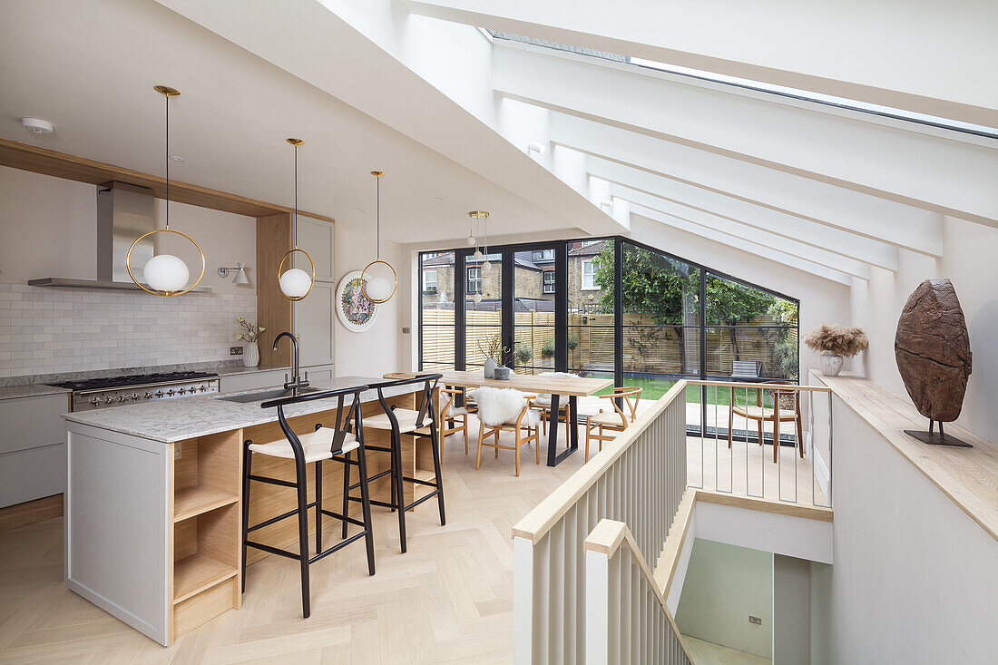 Küche mit Kücheninsel und Essbereich in offenem Raum mit Dachverglasung