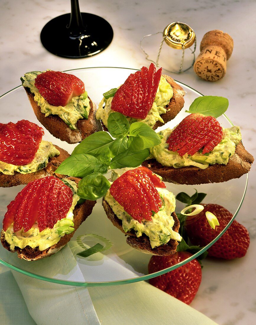 Snacks with avocado puree & strawberries on glass plate