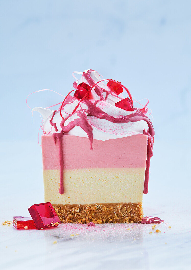 No-bake red skins cheesecake slice with pink chocolate drizzle, strawberry jelly and Italian meringue