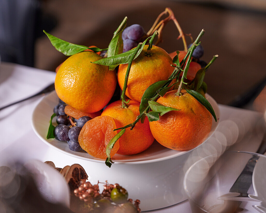 Obstschale mit Mandarinen, getrocknete Aprikosen und Weintrauben