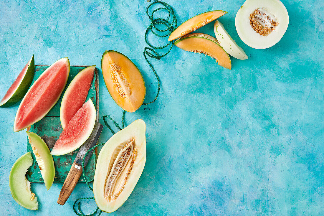 An assortment of melons on a blue background