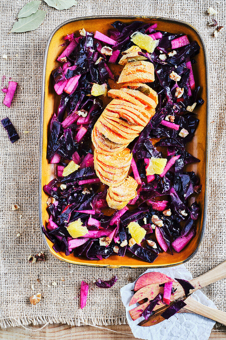 hassleback sweet potatoes on orange-red cabbage salad