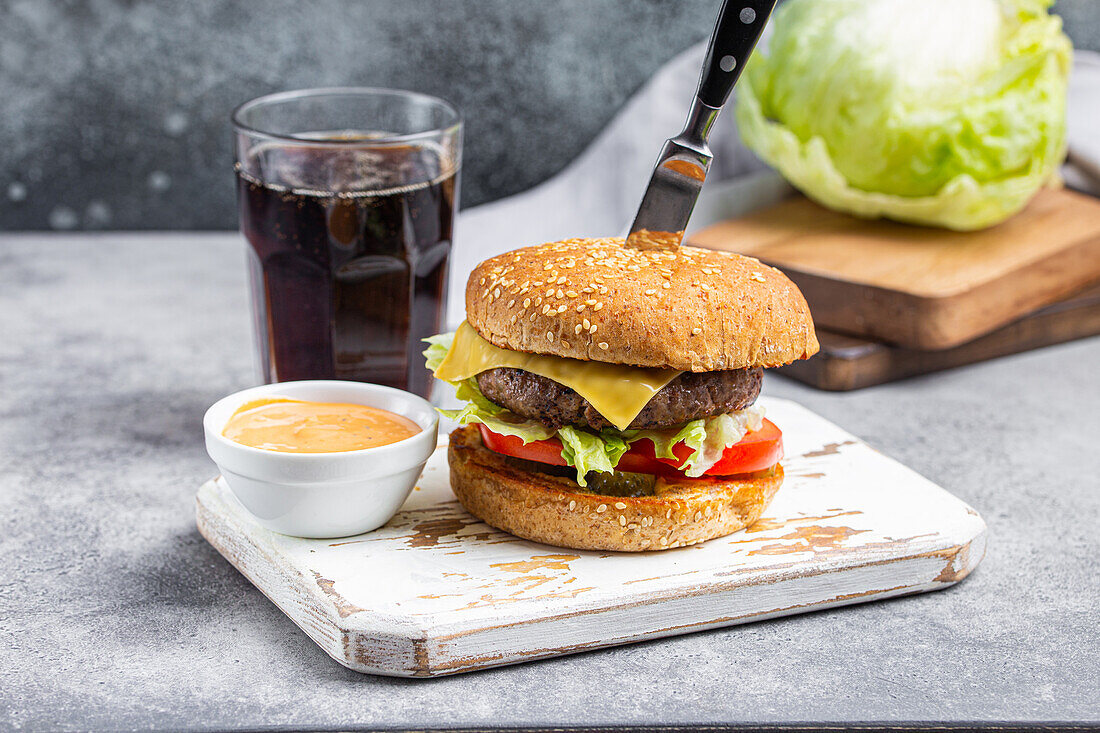 Beef Burger mit Cheddar, Salatblatt und Tomate dazu Dip und Cola