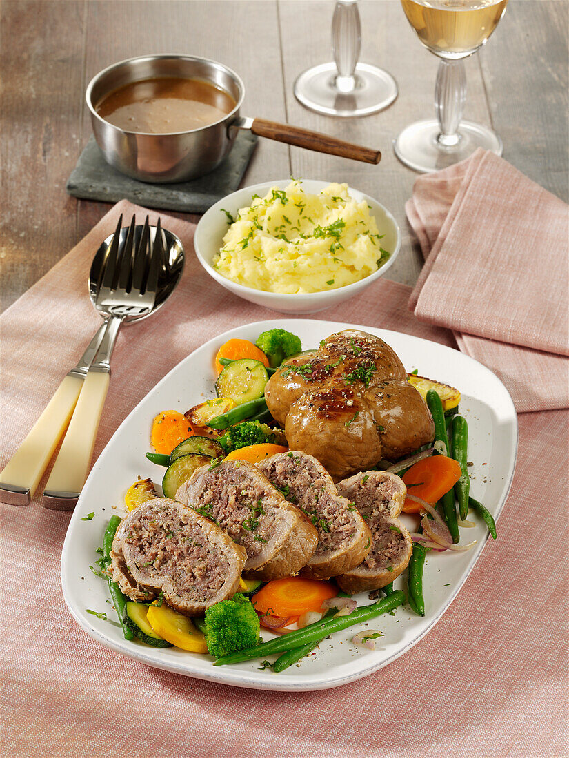 Veal roulades with minced meat stuffing on vegetables