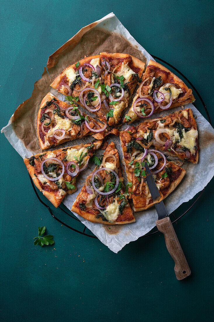 Vegan pizza with soy crumbles, onions and rocket, topped with a vegan cheese