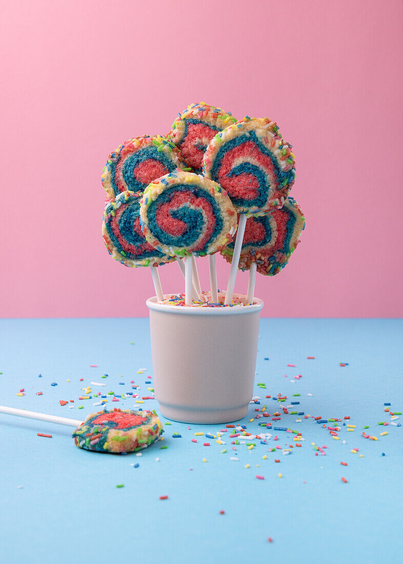 Vegan shortbread biscuits with rainbow sugar sprinkles on a stick