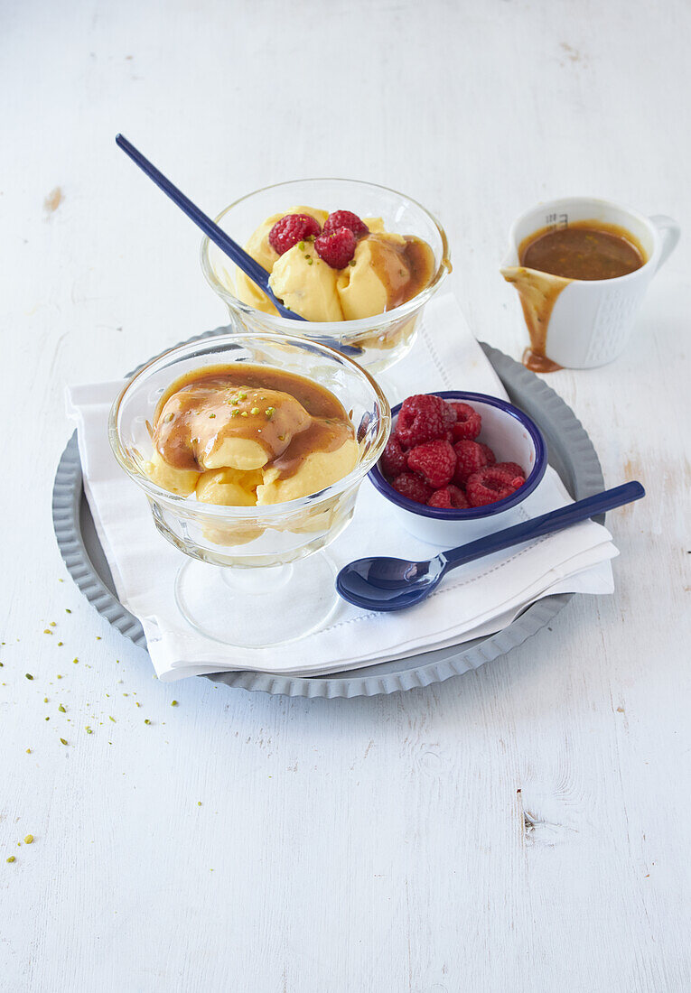 Frozen-Mango-Creme mit Karamellsauce und frischen Himbeeren