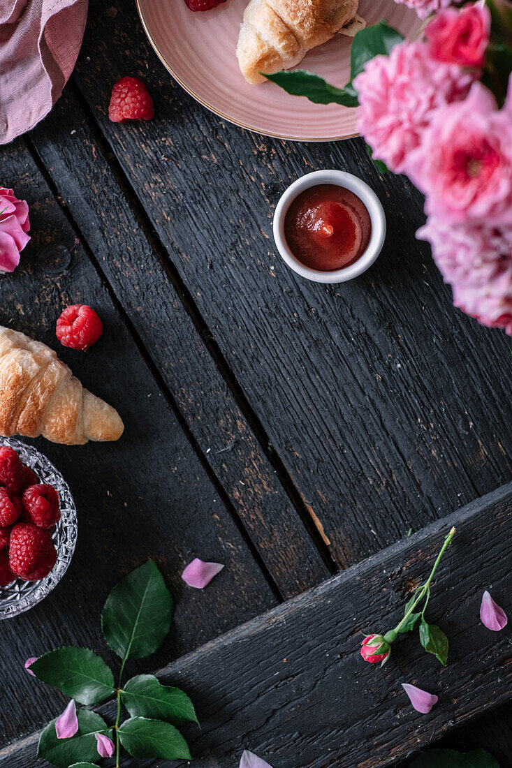 A breakfast table with croissants and raspberries