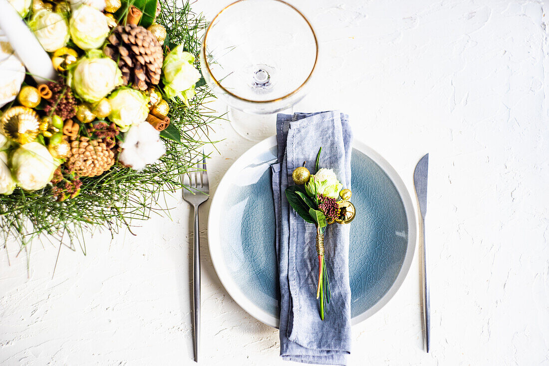 Gedeck für festliches Weihnachtsessen mit Stoffserviette und weißer Rose