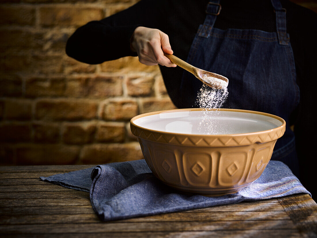 Flour being added to a mixing bowl