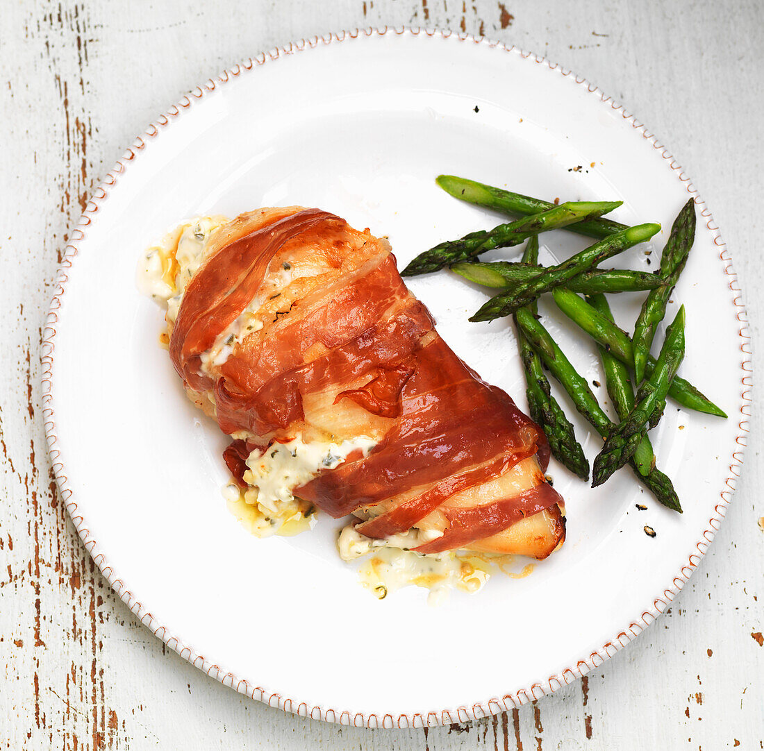 Stuffed chicken breast wrapped with Parma ham and green asparagus