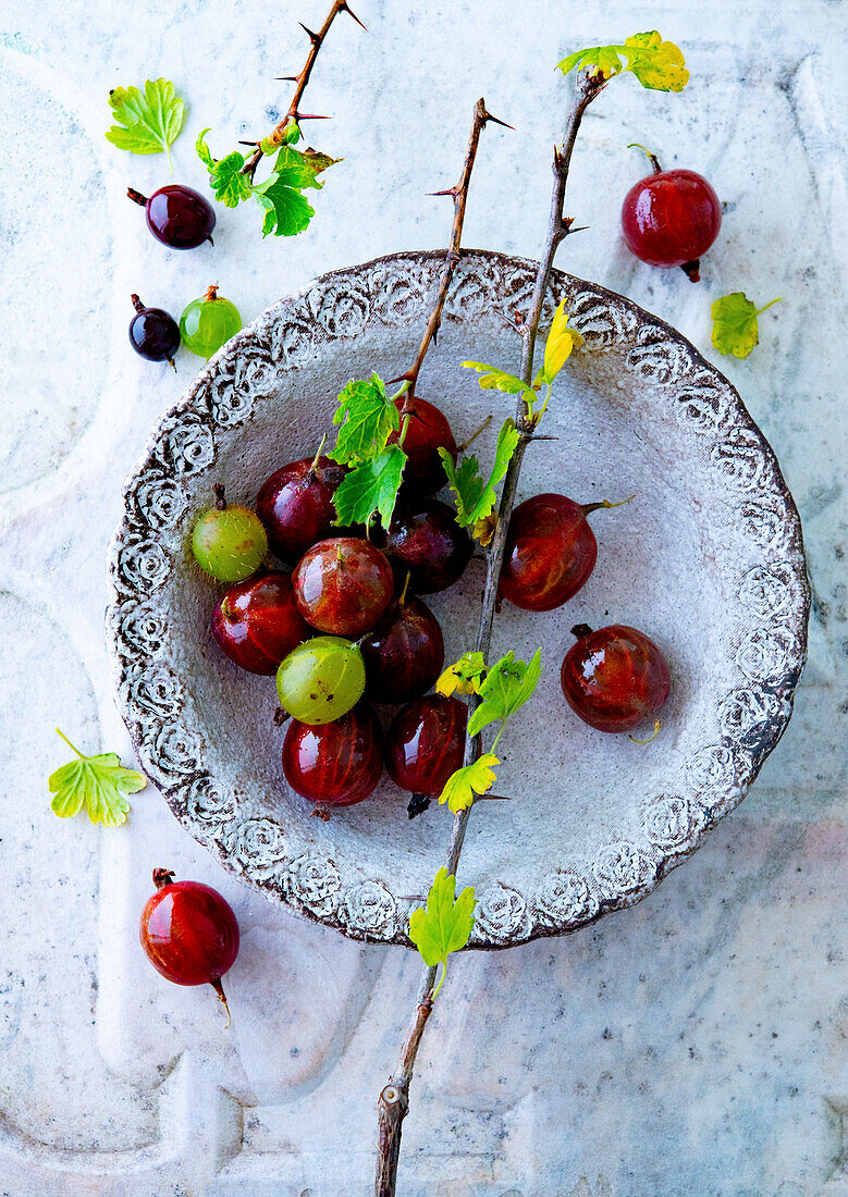 Green and red gooseberries in a bowl