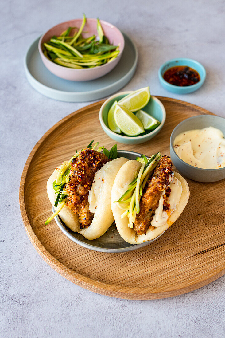 Oven baked buttermilk chicken with sourdough breadcrumbs served in Bao with zucchini noodle salad