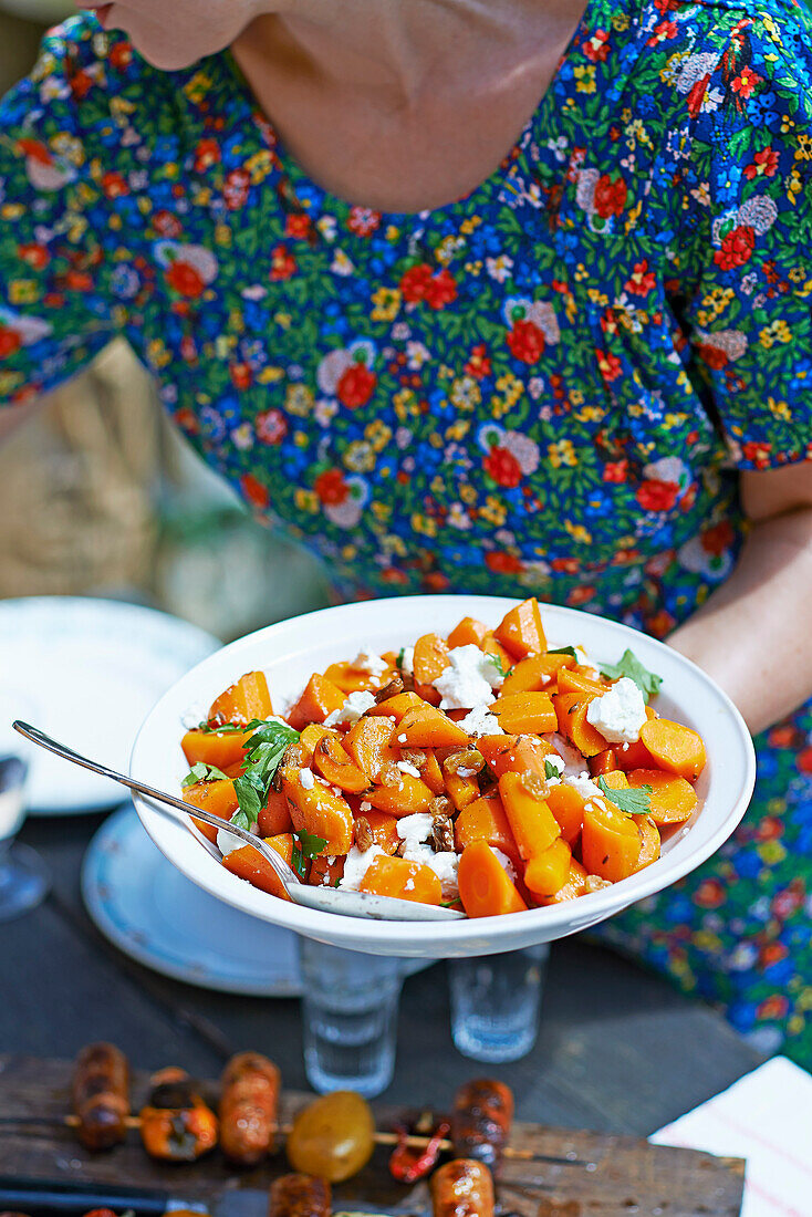 Frau serviert Karotten-Feta-Salat aus dem Nahen Osten
